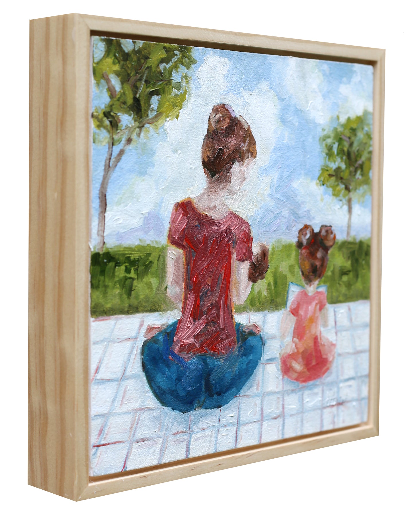 Framed artwork of a woman and child sitting together outdoors.
