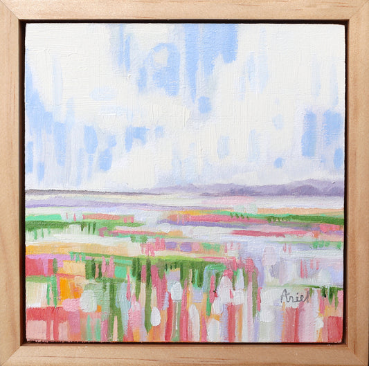 Abstract landscape painting with colorful fields and a blue sky, framed in wood.