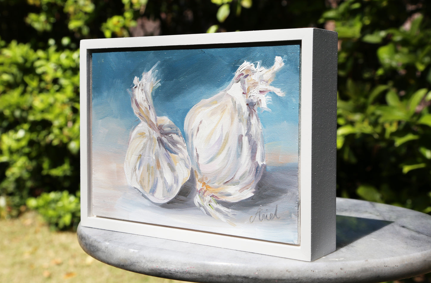 Introduce a touch of elegance to your home with Always Garlic. This original oil painting comes ready to hang in a white frame, and features a beautiful depiction of garlic in shades of blue. Elevate your home decor with this contemporary and fine art piece.