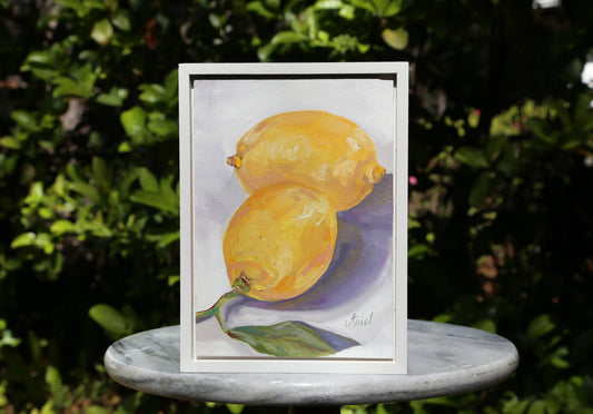 This Lemons #1 fine art oil painting captures the essence of a vibrant still life, perfect for adding a touch of elegance to any home decor. With a sleek white frame, this ready to hang piece is a must-have for any art lover. Bring a burst of color and sophistication into your space.